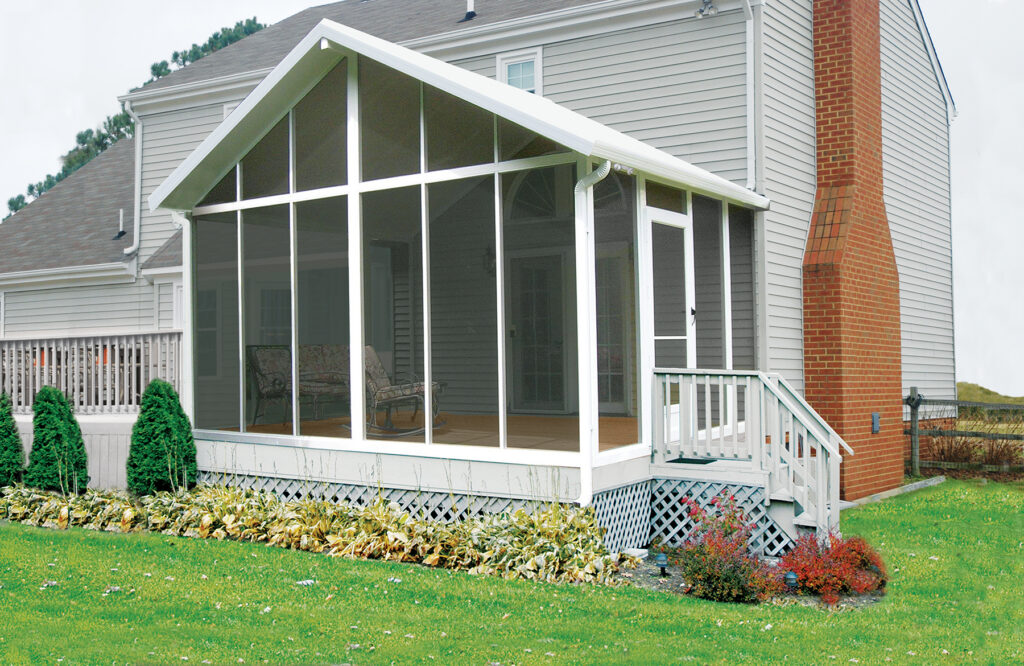 Exterior view of a white gabled screen room with a 15-year warranty, featuring a latticed base and wooden steps leading to a green lawn.
