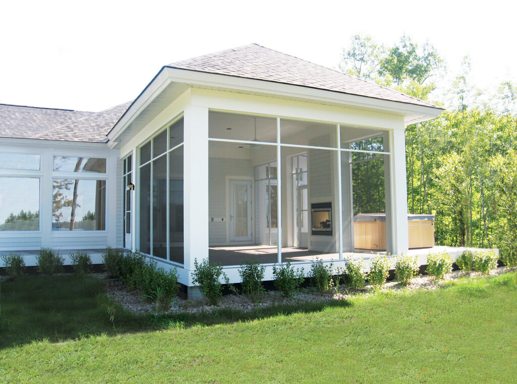 Exterior of a large white screen room built with heavy-duty extruded aluminum framing and a shingled hip roof attached to a modern home.